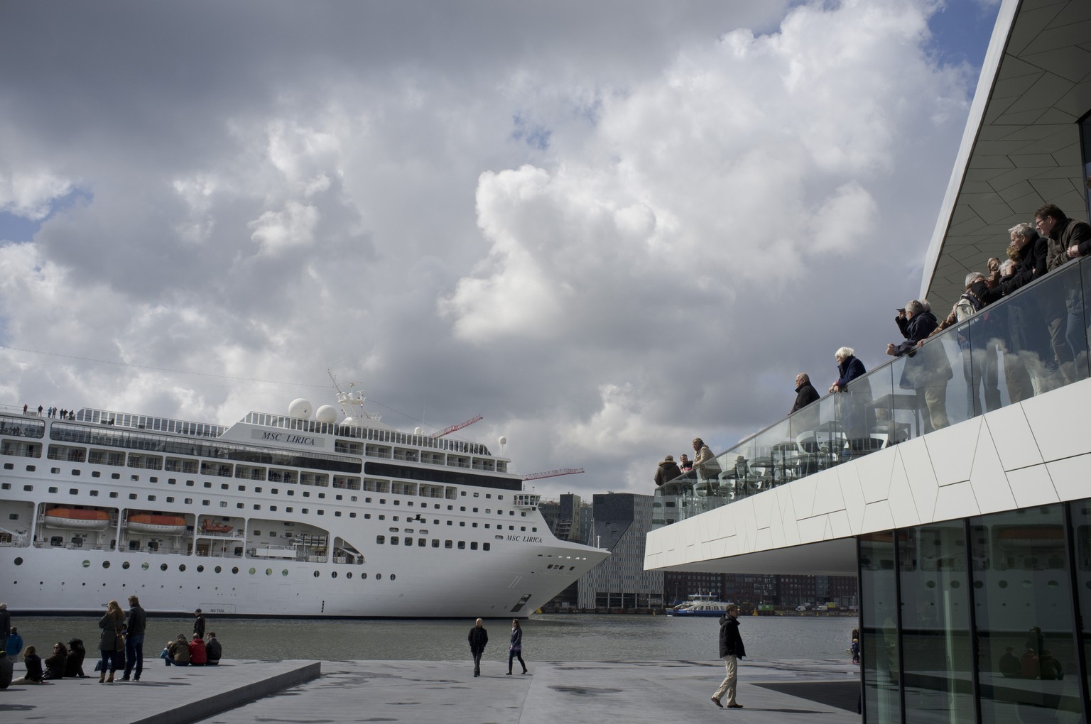 FILE - People visiting the new EYE Film Instute take pictures of the MSC Lirica, a Panama-registered cruise ship passing on IJ river in Amsterdam, Netherlands, April 21, 2012. Amsterdam municipality w ...