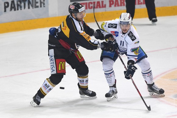 Luganos Steve Hirschi, links, kaempft um den Puck gegen Ambris Lukas Lhotak, rechts, beim Eishockeyspiel der National League A zwischen dem HC Lugano und dem HC Ambri Piotta, in der Resega Eishalle in ...