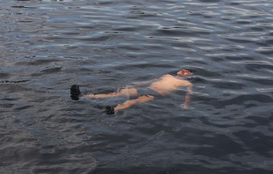 epa09361961 A Kashmiri man tries to beat the heat by swimming in the Nigeen lake in Srinagar, the summer capital of Indian Kashmir, 24 July 2021. EPA/FAROOQ KHAN