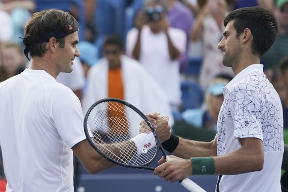 Novak Djokovic, right, of Serbia, shakes hands with Roger Federer, left, of Switzerland, after winning their finals match at the Western &amp; Southern Open tennis tournament, Sunday, Aug. 19, 2018, i ...