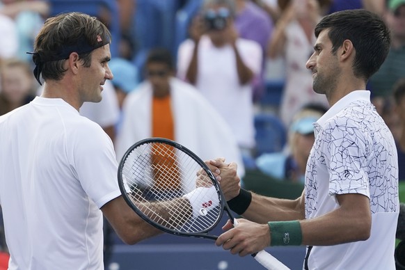 Novak Djokovic, right, of Serbia, shakes hands with Roger Federer, left, of Switzerland, after winning their finals match at the Western &amp; Southern Open tennis tournament, Sunday, Aug. 19, 2018, i ...