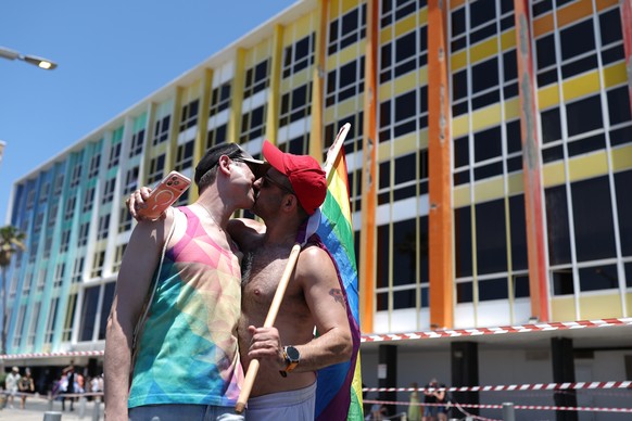 epa13032653 Two participants kiss during the Tel Aviv Pride Parade along the beachfront promenade in Tel Aviv, Israel, 12 June 2026. Attracting tens of thousands of participants under the slogan ' ...
