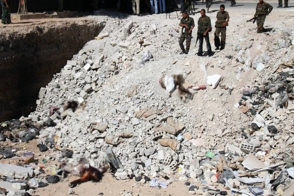 Assads Soldaten stehen 2012 vor einem Massengrab in einem Vorort von Damaskus.