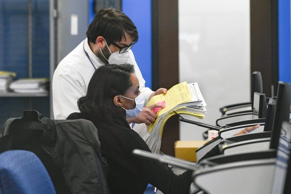 epa08797051 Election official look over absentee mail ballots to be scanned at the Gwinnett County Elections headquarters in Lawrenceville, Georgia, USA, 03 November 2020. Americans vote on Election D ...