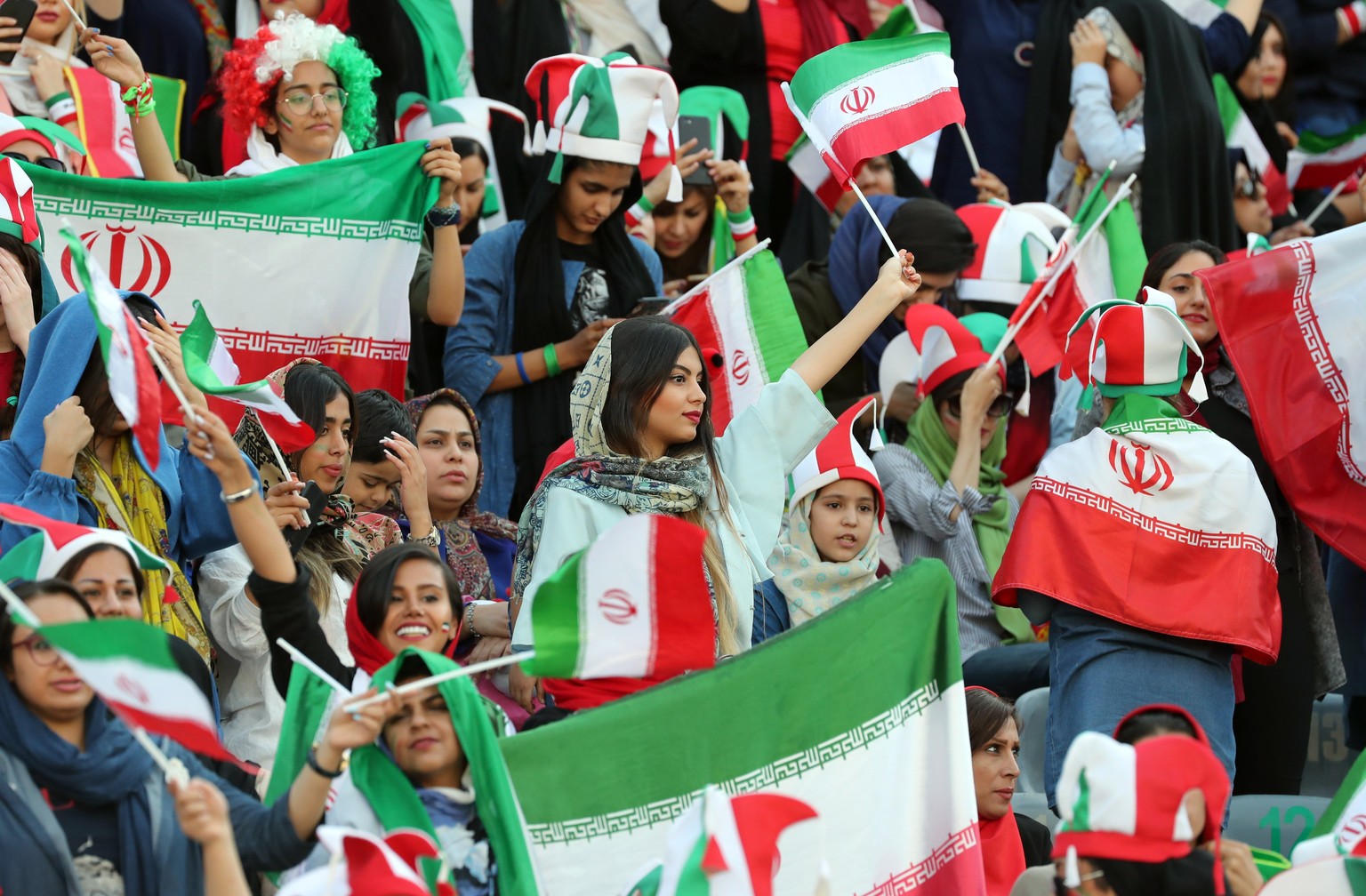 epa07910125 Iranian women cheer during the FIFIA World Cup qualification match between Iran and Cambodia, at the Azadi stadium in Tehran, Iran 10 October 2019. Media reported that thousands of Iranian ...