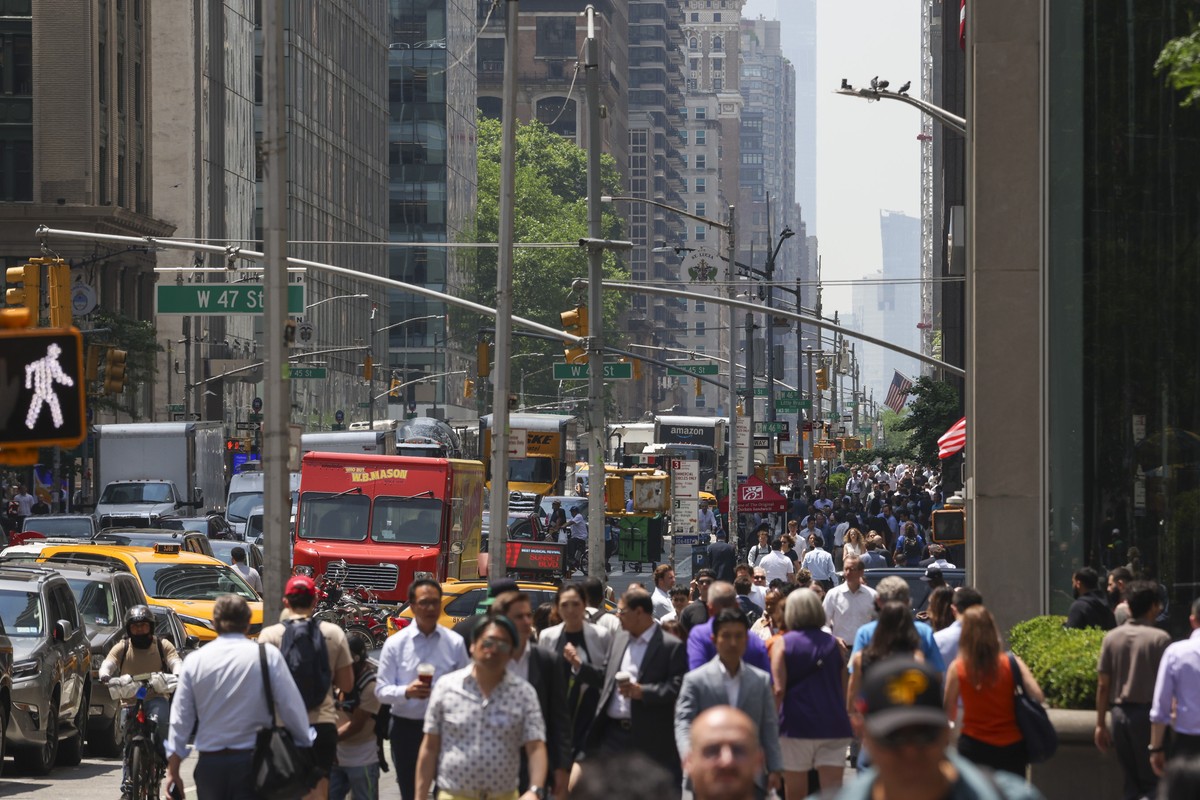 epa12158564 Cars drive up and people walk on 6th Avenue, as climbing temperatures and light haze from Canadian wildfires effect the city and the surrounding metropolitan area in New York, New York, US ...