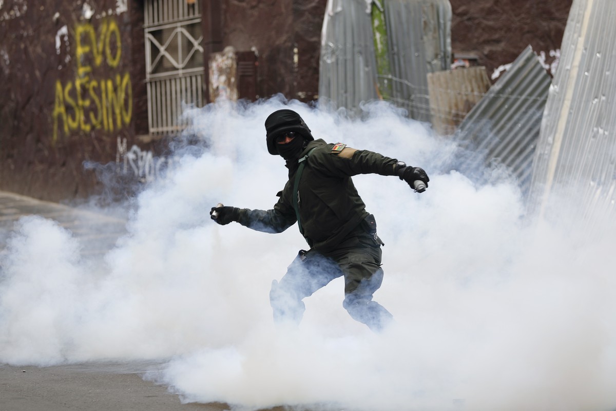 A Bolivian police officer hurls tear gas at backers of former President Evo Morales during clashes, in La Paz, Bolivia, Wednesday, Nov. 13, 2019. Bolivia's new interim president Jeanine Anez face ...