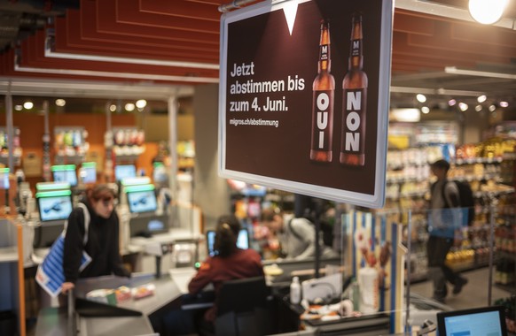 Plakate weisen auf die Abstimmung zum moeglichen Verkauf von alkoholischen Getraenken in der Migros hin, am Dienstag, 24. Mai 2022 in der Migros Filiale Lorraine in Bern. Anfang Juni 2022 koennen die  ...