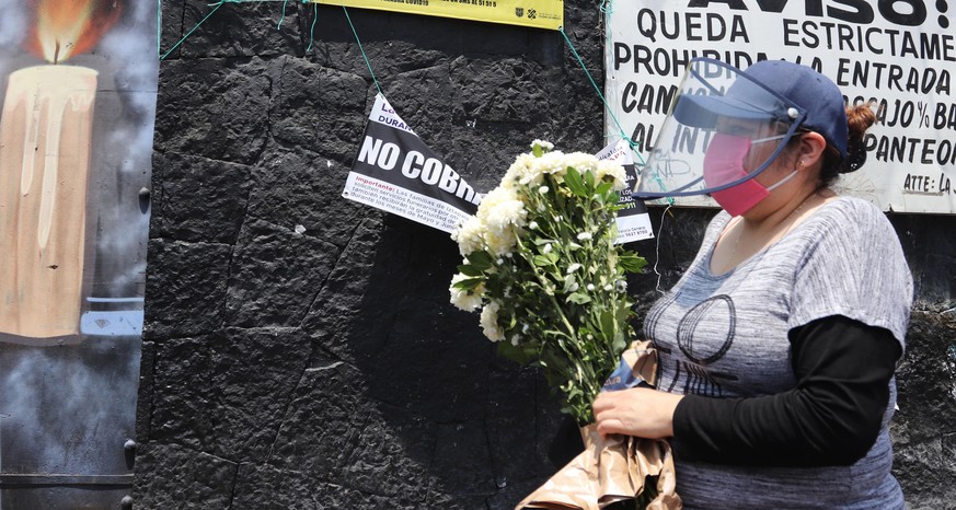 epa08413612 A women stands outside one of the main cemeteries in Mexico City waiting to visit the graves of her relatives to celebrate Mother&#039;s Day, in Mexico City, Mexico, 10 May 2020. These pla ...