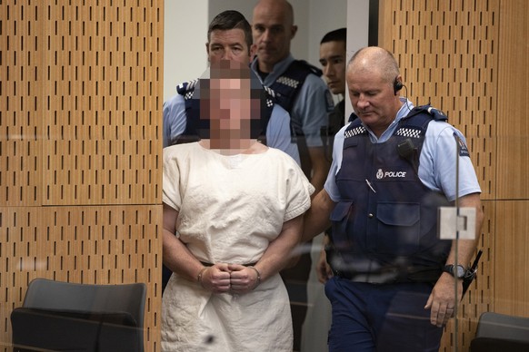 epa07441048 The man charged in relation to the Christchurch mosque massacre Brenton Harrison Tarrant (Pixelated) is lead into the dock for his appearance for murder, in the District Court, Christchurc ...