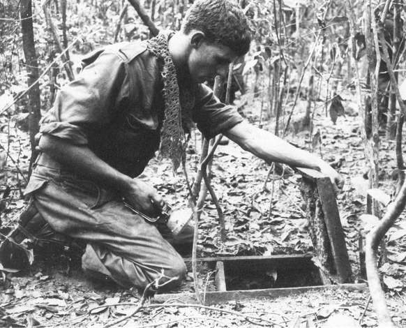 Ein australischer Soldat macht sich in der Frühphase des Krieges daran, in einen vietnamesischen Tunnel einzusteigen.