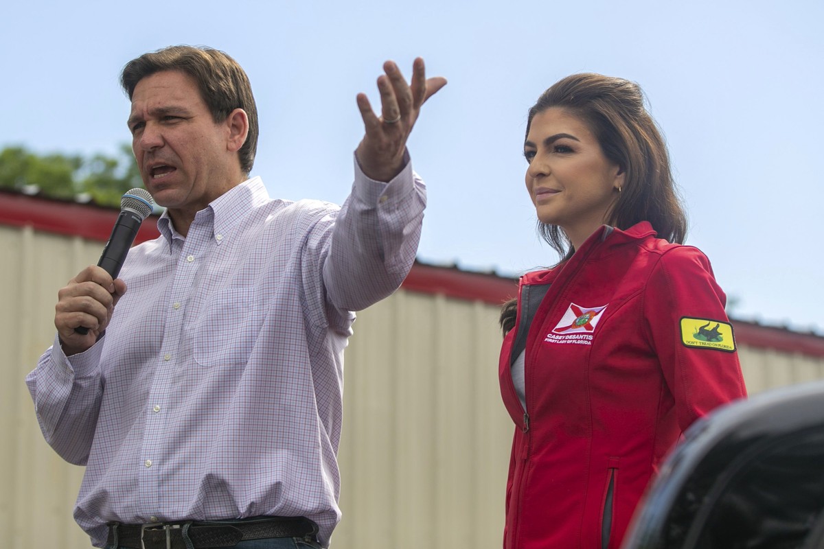 Republican presidential candidate Florida Gov. Ron DeSantis stands with his wife, Casey DeSantis, in the bed of a pickup truck as he addresses an overflow crowd at the Never Back Down event outside th ...