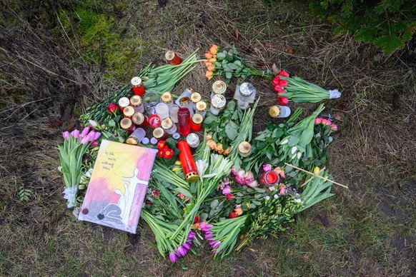 30.01.2023, Niedersachsen, Wunstorf: Blumen und Kerzen liegen an einer Tannenbaumschonung in Wunstorf-Blumenau in der Region Hannover. Nach der T�tung eines 14-j�hrigen Jungen sind die Hintergr�nde de ...