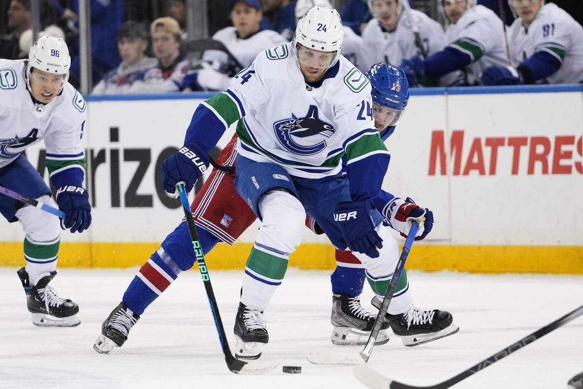 Vancouver Canucks' Pius Suter (24) drives past New York Rangers' Alexis Lafreniere (13) during the first period of an NHL hockey game Monday, Jan. 8, 2024, in New York. (AP Photo/Frank Frank ...