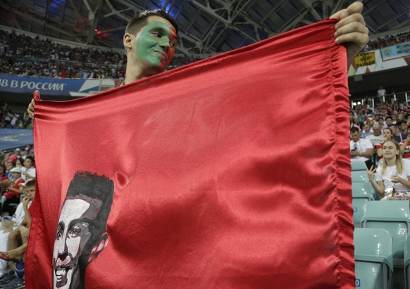 A supporter holds a flag depicting Portugal&#039;s Cristiano Ronaldo as he waits for start of the round of 16 match between Uruguay and Portugal at the 2018 soccer World Cup at the Fisht Stadium in So ...