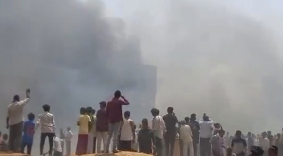 People watch smoke rising after an airplane crashed in Ahmedabad, Gujarat state, India, Thursday, June 12, 2025. (Mohan Nakum via AP)
India Plane Crash