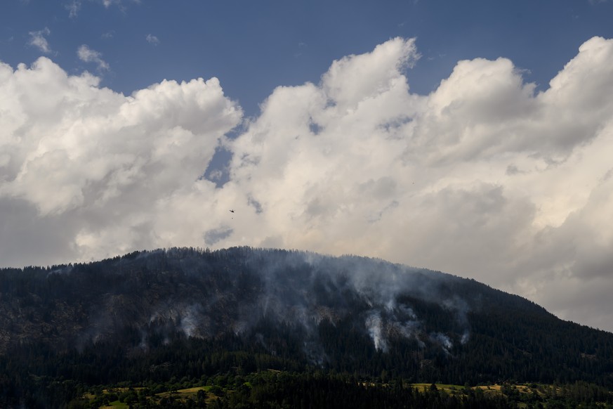 Un helicoptere Super Puma verse de l&#039;eau sur la fumee qui s&#039;echappe de la foret en feu au dessus des communes de Bitsch et Ried-Moerel le mardi 18 juillet 2023 depuis Termen. Les h�licoptere ...