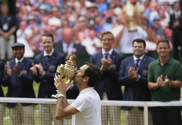 Switzerland&#039;s Roger Federer kisses the trophy after defeating Croatia&#039;s Marin Cilic to win the Men&#039;s Singles final match on day thirteen at the Wimbledon Tennis Championships in London  ...