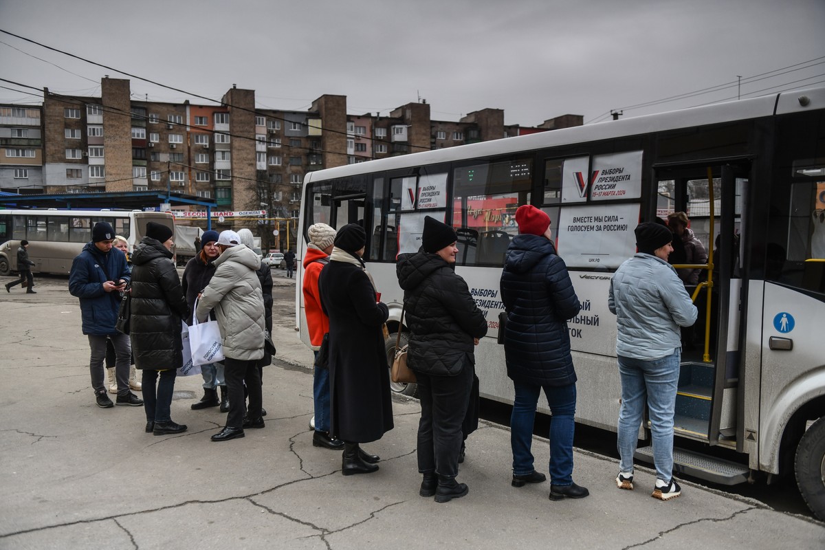 epa11224597 Local people wait to cast their ballots at the mobile polling station in the bus during presidential elections in Donetsk, Russian controlled part of Ukraine, 16 March 2024. The Federation ...