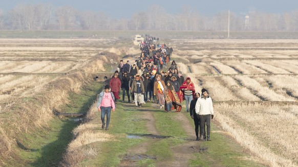 epa08263903 Refugees walk back after a failed attempt to pass the Greek border near the Meric (Evros) River, as they try to find a way to reach Greek territory at the Turkish-Greek border in the Ipsal ...