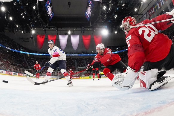 Great Britain's Josh Waller, left, scores to 3-1 against Switzerland's Ken Jager, center, and Switzerland's goaltender Reto Berra, during the 2026 IIHF Men's Ice Hockey World Champ ...