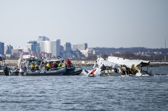 epa11865268 A handout photo made available by the US Coast Guard shows the wreckage of a commercial airplane (R) that collided with an US Army Black Hawk helicopter on Wednesday night in the Potomac R ...