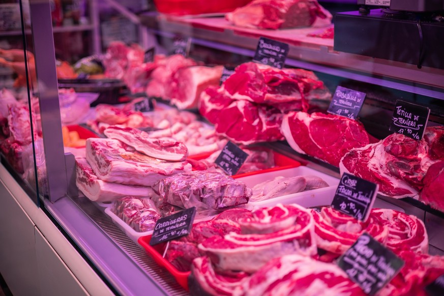 Nahaufnahme-Bild zeigt eine Vielzahl von frischem Fleisch auf der Glastheke einer Metzgerei. Vom Rind- bis zum Schweinefleisch- und Lammfleischsortiment bietet das Sortiment eine große Auswahl an Flei ...