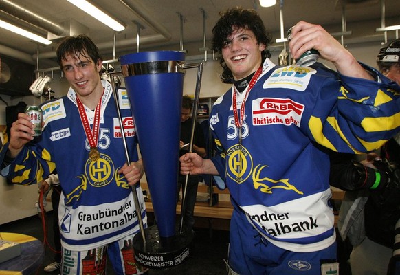 Die Davoser Brueder Marc und Dino Wieser, rechts, feiern mit dem Pokal in der Garderobe den Schweizermeistertitel, im siebten Playoff Eishockey Meisterschaftsspiel der Nationalliga A zwischen dem HC D ...