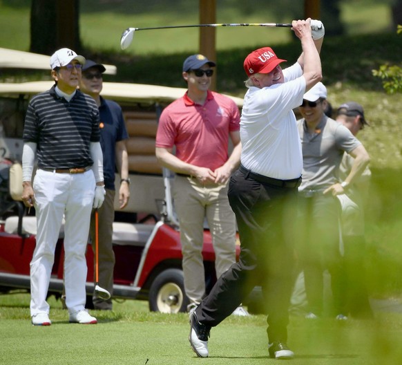 U.S. President Donald Trump, right, plays golf with Japanese Prime Minister Shinzo Abe, left, at Mobara Country Club in Mobara, south of Tokyo, Sunday, May 26, 2019. (Ren Onuma/Kyodo News via AP)