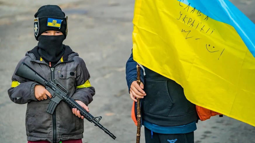 Kinder im Ukraine-Krieg mit einem Plastikgewehr.