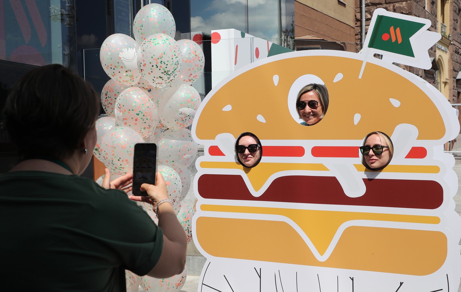 epaselect epa10009479 A woman takes a picture as people visit a former McDonald&#039;s restaurant during reopening under a new brand Vkusno I Tochka in Moscow, Russia, 12 June 2022. On 14 March 2022,  ...