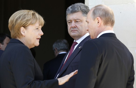 FILE - In this June 6, 2014, file photo, German Chancellor Angela Merkel, left, Russian President Vladimir Putin, right, and then Ukrainian president-elect Petro Poroshenko, center, talk as they take  ...