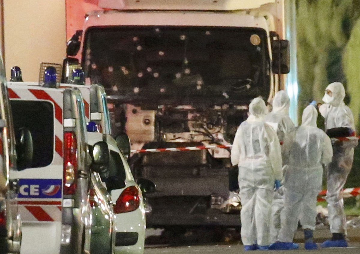 French police forces and forensic officers stand next to a truck July 15, 2016 that ran into a crowd celebrating the Bastille Day national holiday on the Promenade des Anglais killing at least 60 peop ...