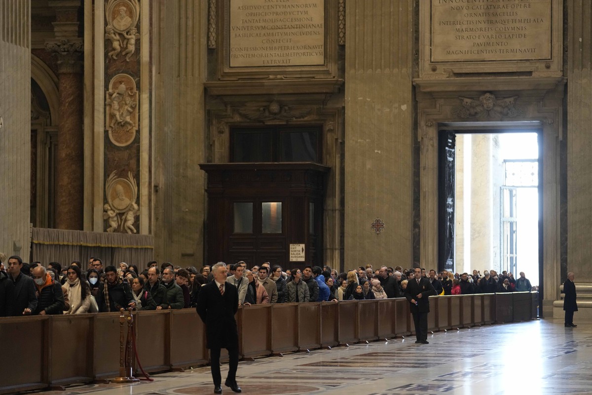 People line up to pay homage at Pope Emeritus Benedict XVI laying out in state inside St. Peter's Basilica at The Vatican, Monday, Jan. 2, 2023. Benedict XVI, the German theologian who will be re ...