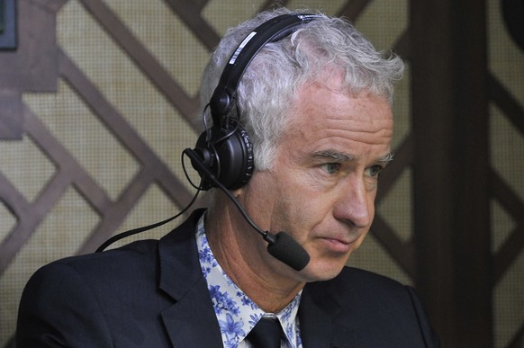 Former champion tennis player John McEnroe sits in the commentary box at centre court as France's Jo-Wilfried Tsonga plays against Serbia's Novak Djokovic during their men's singles fourth round match ...