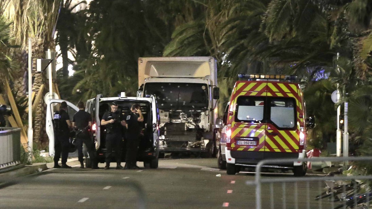 epa05425148 Police officers stand guard near the truck after it crashed into the crowd during the Bastille Day celebrations in Nice, France, 14 July 2016. According to reports, about 70 people died an ...