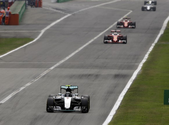 Mercedes driver Nico Rosberg of Germany, left, leads the race ahead of Ferrari drivers Sebastian Vettel of Germany, center, and Kimi Raikkonen of Finland during the Italian Formula One Grand Prix at t ...