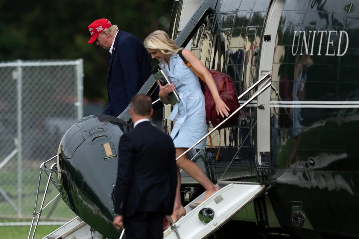 President Donald Trump and executive assistant Natalie Harp step off from Marine One upon they arrival at the Ellipse just outside of the White House, Sunday, Aug. 16, 2026, in Washington. (AP Photo/J ...