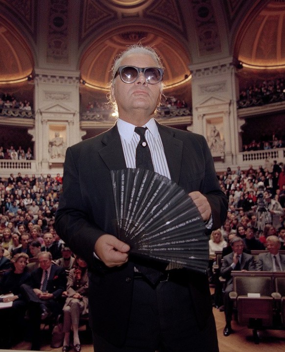 Karl Lagerfeld, Chanel's German fashion designer, holds his fan as he enters the main hall of the Sorbonne, France's oldest and most famous university.  18, 1994. Lagerfeld fielded...