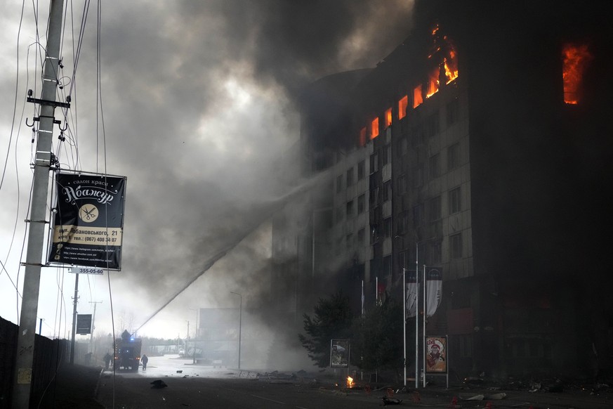 Firefighters hose down a burning building after bombing in Kyiv, Ukraine, Thursday, March 3, 2022. (AP Photo/Efrem Lukatsky)