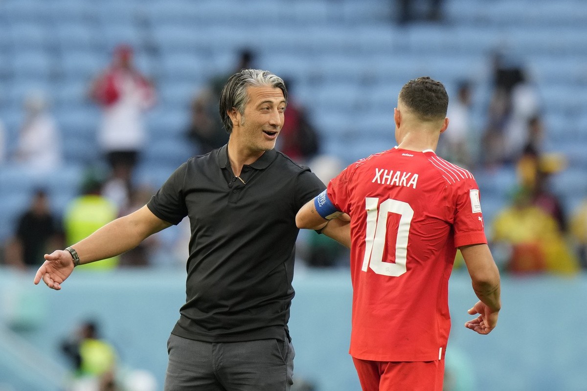 Switzerland's head coach Murat Yakin, left, celebrates with teammates Granit Xhaka at the end of the World Cup group G soccer match between Switzerland and Cameroon, at the Al Janoub Stadium in A ...