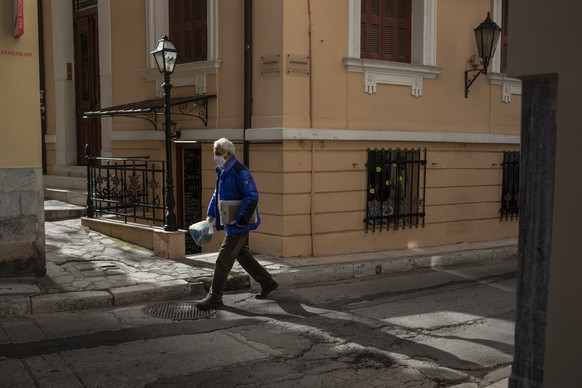 A man wearing a face mask to curb the spread of the coronavirus walks in Plaka district of Athens on Tuesday, Feb. 9, 2021. Authorities in Greece have extended a curfew in the country&#039;s two large ...