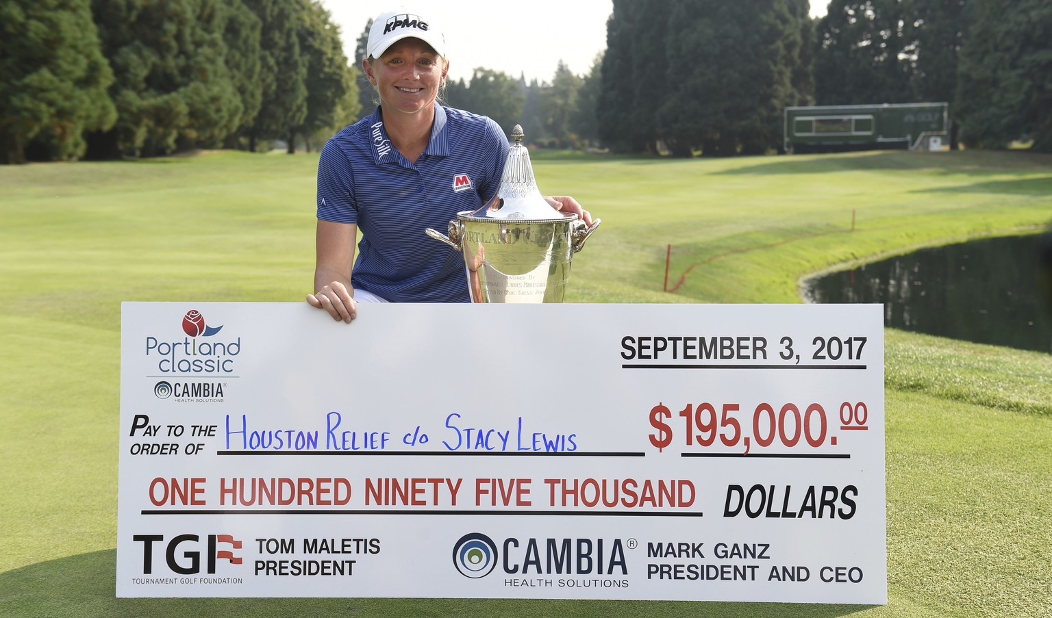 Stacy Lewis poses with the trophy and a check after winning the the Cambia Portland Classic golf tournament in Portland, Ore. on Sunday, Sept. 3, 2017. Lewis is donating her winnings to the Houston Re ...