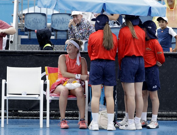 Switzerland&#039;s Timea Bacsinszky and ball kids sit under an umbrella as rain halts play in her second round match against Russia&#039;s Natalia Vikhlyantseva at the Australian Open tennis champions ...