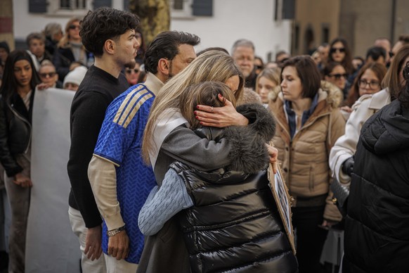 KEYPIX - The mother of a victim holds a child in her arms as approximately a thousand people gathered to pay tribute to the victims of the tragedy in Crans-Montana and to call for "justice and tr ...