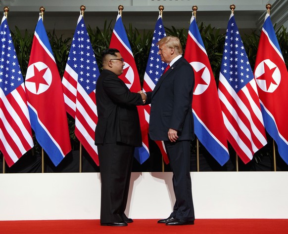 FILE - North Korean leader Kim Jong Un, left, and U.S. President Donald Trump shake hands prior to their meeting on Sentosa Island in Singapore on June 12, 2018. North Korea basked in the global limel ...