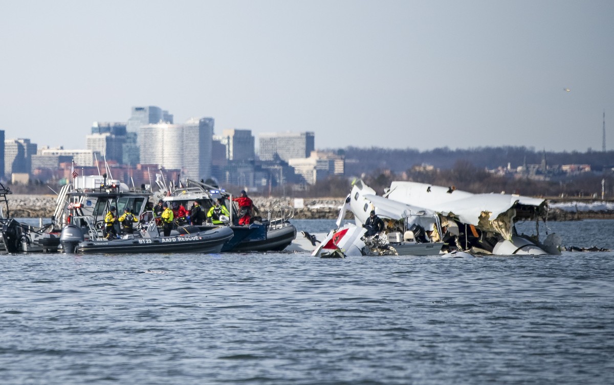 epa11865268 A handout photo made available by the US Coast Guard shows the wreckage of a commercial airplane (R) that collided with an US Army Black Hawk helicopter on Wednesday night in the Potomac R ...