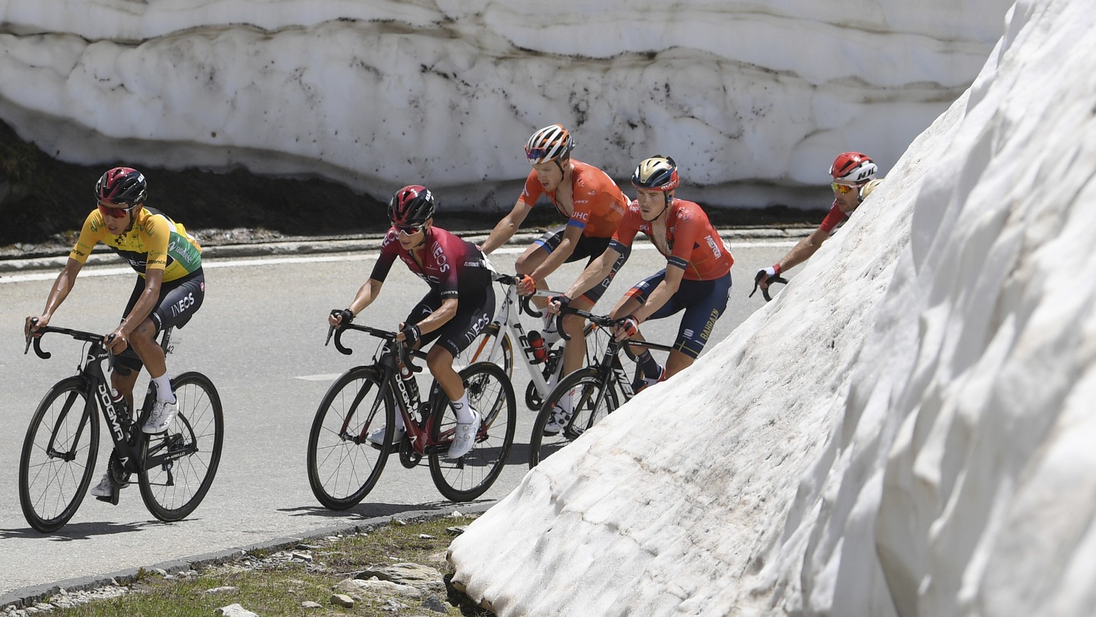 Leader Egan Bernal from Colombia, left, is followed by Ineos team mates and by Australias Rohan Dennis, 4th left, team Bahrain-Merida, at the Nufenen pass during the ninth and final stage, a 101.5 km  ...