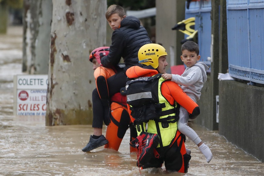 epa07094196 French firefighters save some children during rescue operations in the middle of submerged streets due to heavy rain falls and violent storm that hit Aude department overnight in Trebes, F ...