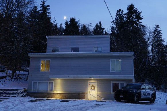 The moon rises on Tuesday, Nov. 29, 2022, as a Moscow police officer stands guard in his vehicle at the home where four University of Idaho students were found dead on Nov. 13, 2022 in Moscow, Idaho.  ...